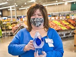 Sheila holds her President’s Award trophy proudly in front of the produce section of her store.